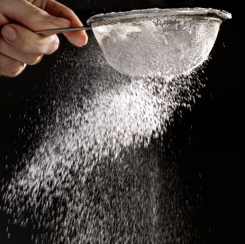 A person sifting flour.