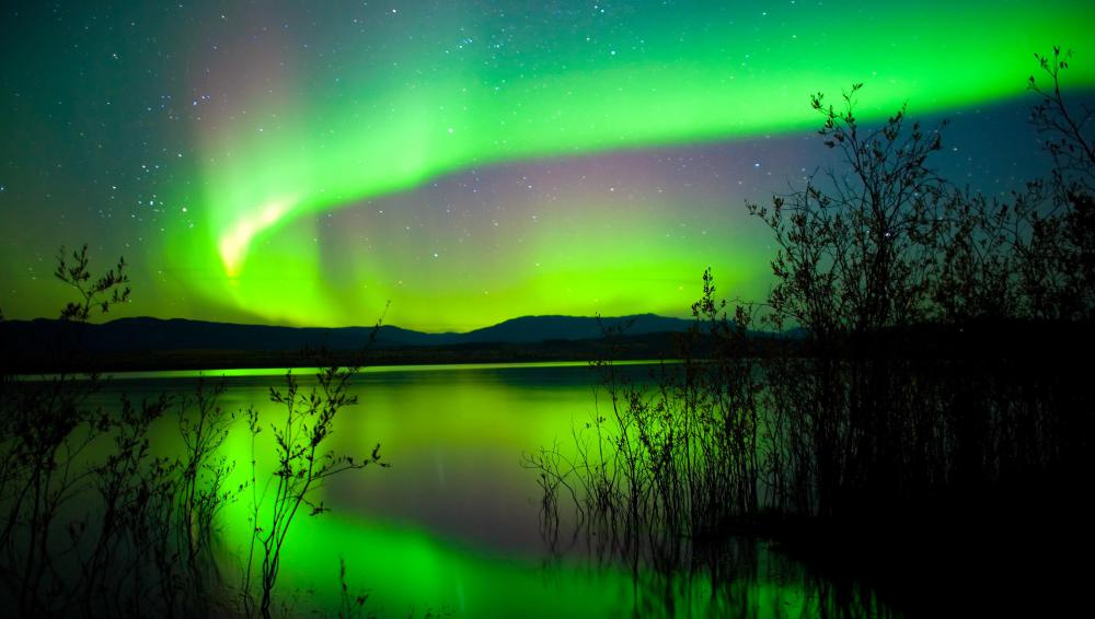 The Aurora Borealis reflecting off a still lake.